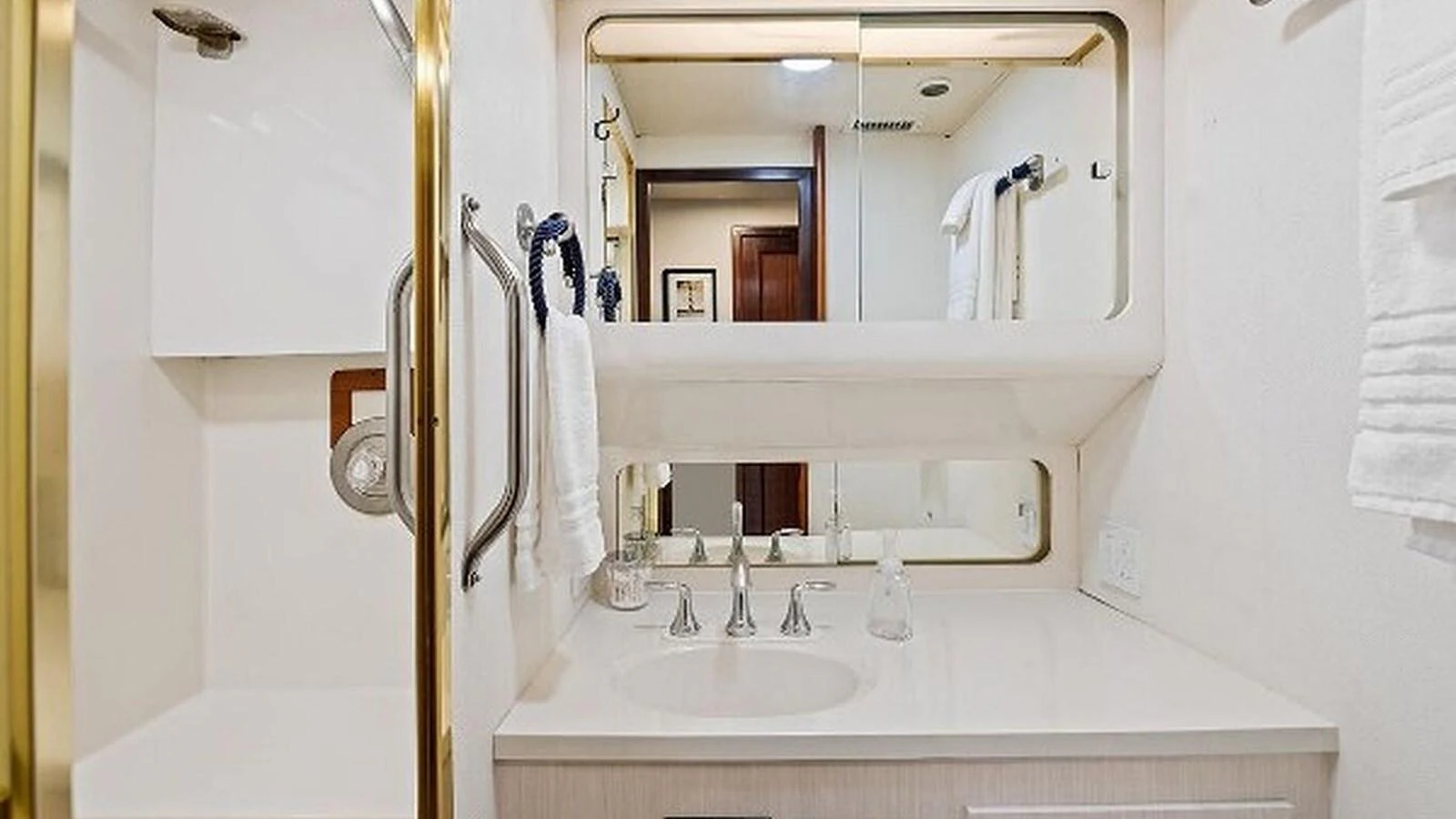 The yacht's bathroom features a clean and modern design with a large mirror and ample counter space. aboard TOP GUN Yacht for Sale