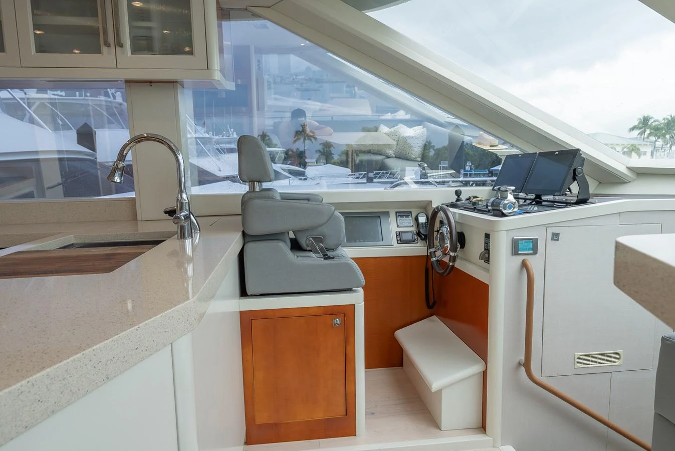 The helm station features modern navigation equipment and a comfortable captain's chair, set against a backdrop of sleek cabinetry and expansive windows. aboard WHISTLE Yacht for Sale