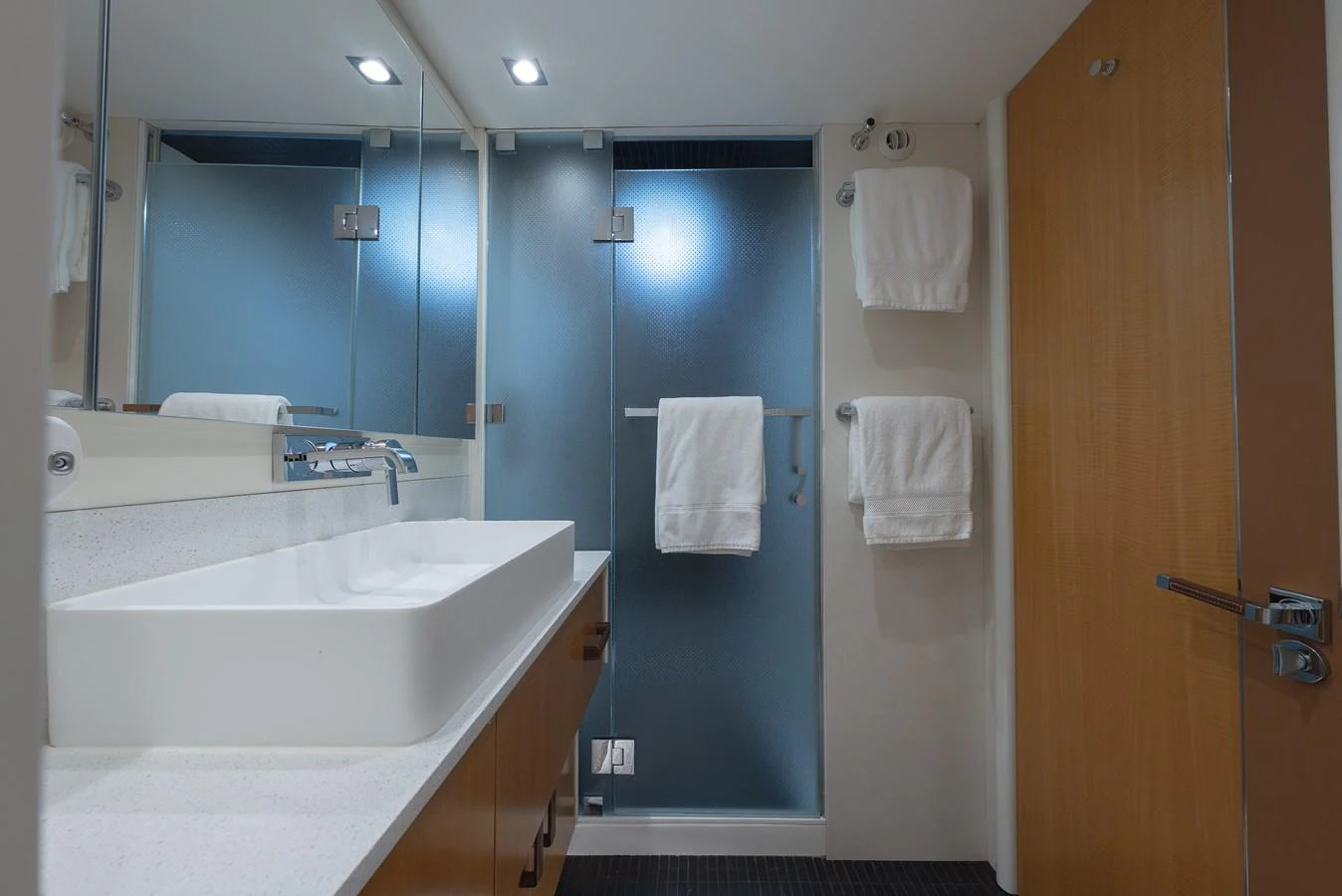 The yacht's bathroom features a modern design with a sleek sink and frosted glass shower. aboard WHISTLE Yacht for Sale
