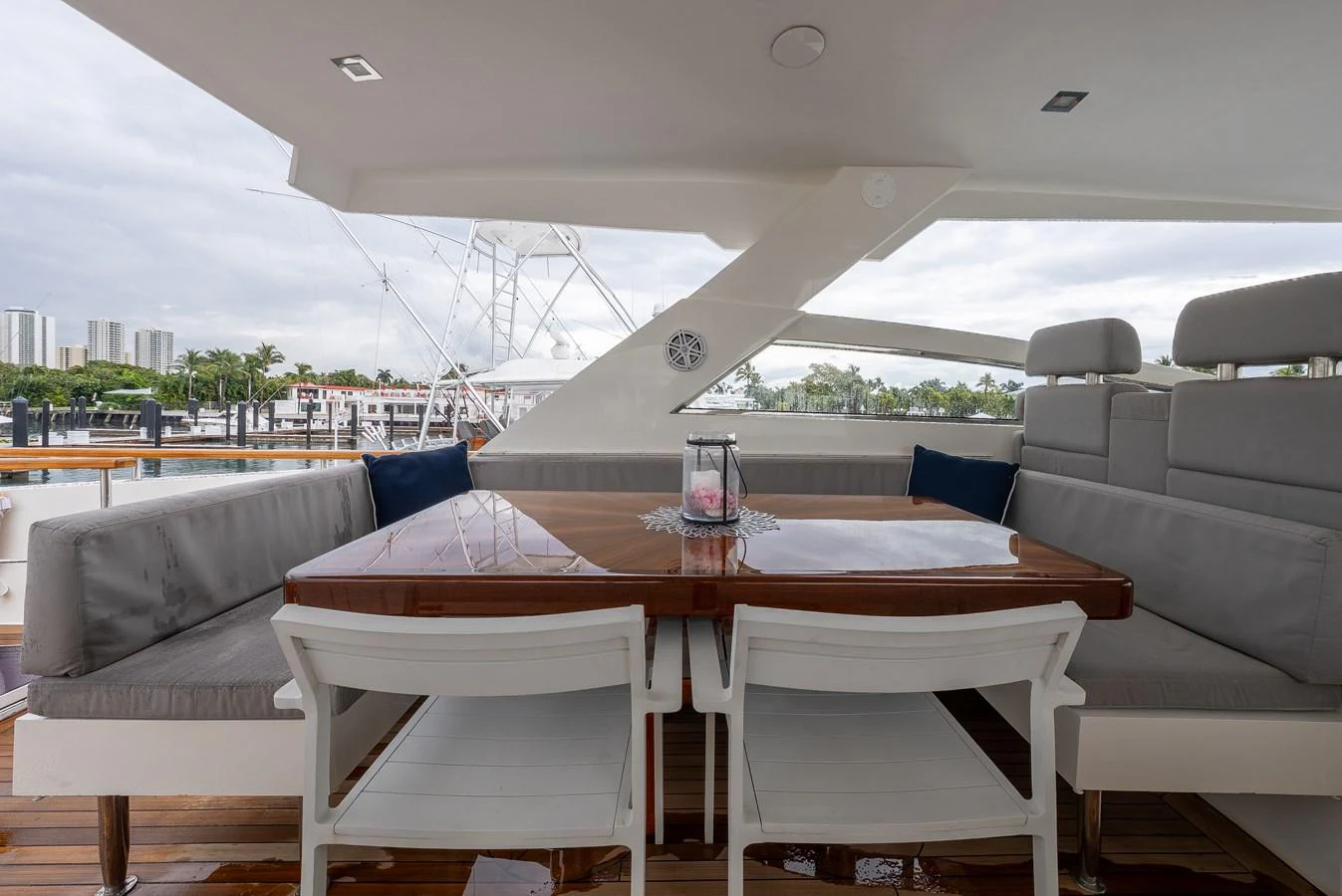 The aft deck features a comfortable dining area with plush seating and a polished wooden table. aboard WHISTLE Yacht for Sale