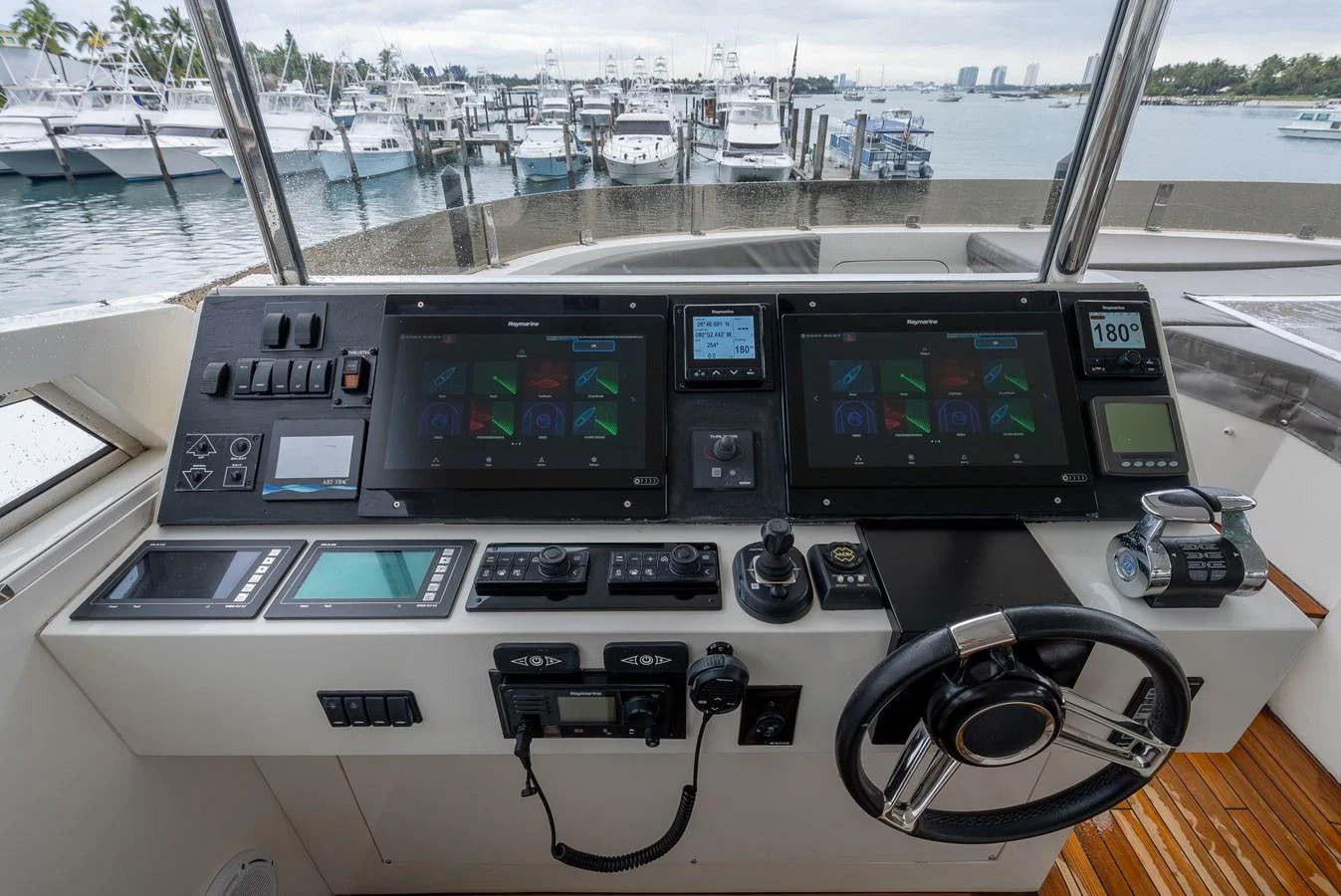 The helm station features advanced navigation equipment and a sleek design, offering a commanding view of the marina. aboard WHISTLE Yacht for Sale