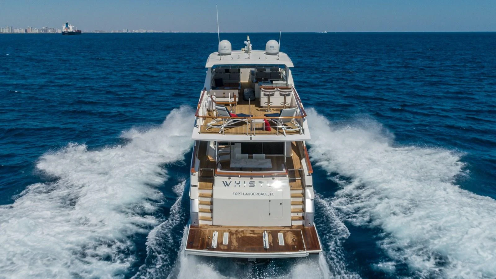 The yacht is seen cruising on the open sea, showcasing its spacious aft deck and sleek design. aboard WHISTLE Yacht for Sale