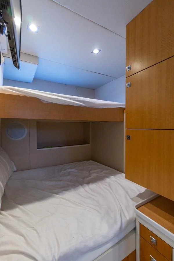 The cozy bunk cabin features warm wood finishes and comfortable bedding. aboard WHISTLE Yacht for Sale
