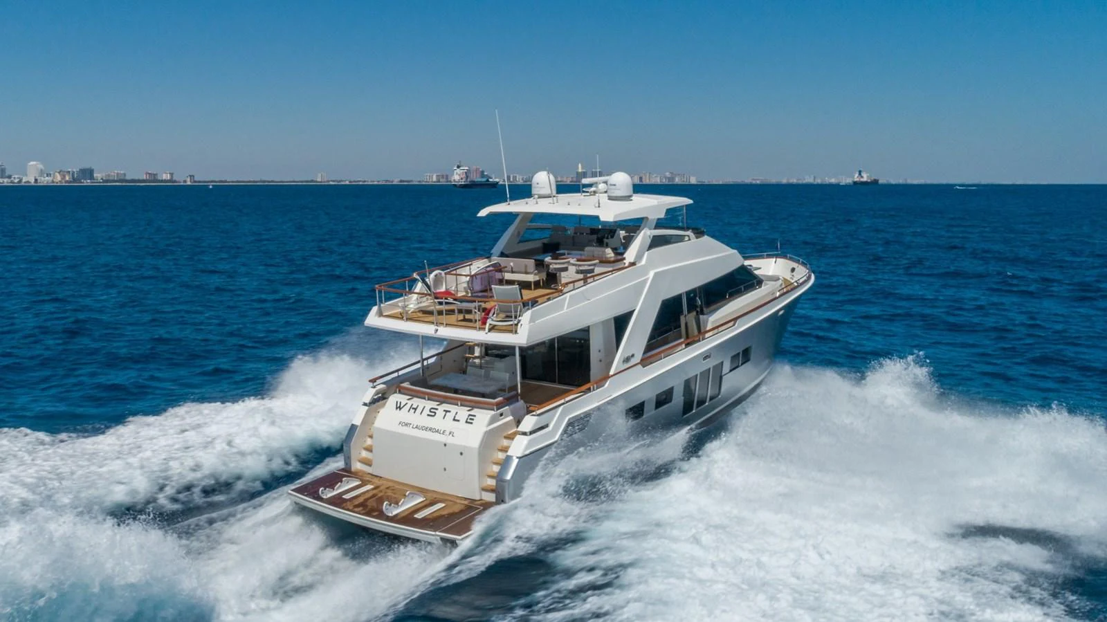 A sleek yacht cruises through the open water, showcasing its modern design and spacious deck. aboard WHISTLE Yacht for Sale