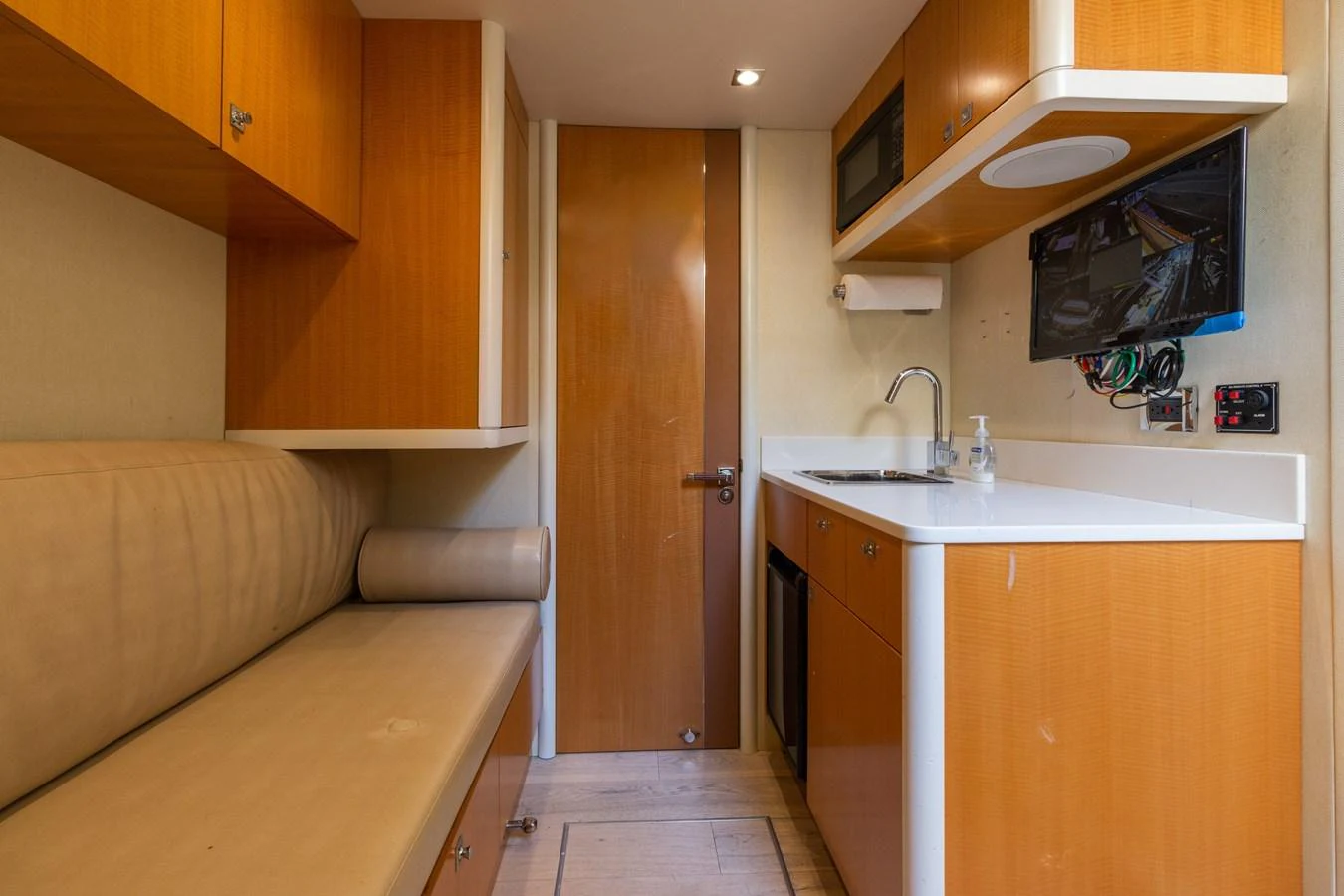 The yacht's galley features warm wood cabinetry, a sleek countertop, and modern appliances. aboard WHISTLE Yacht for Sale