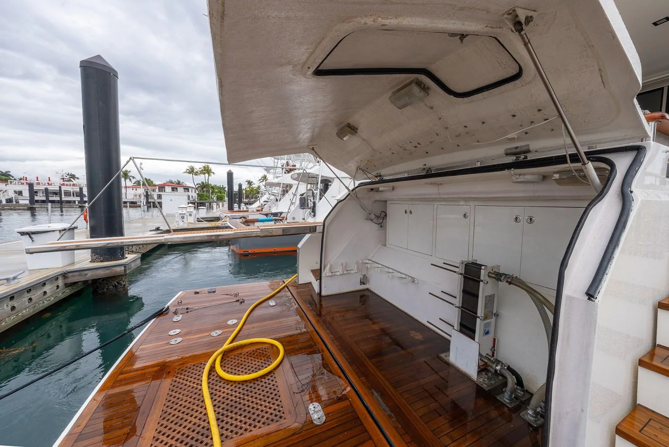 The image showcases a detailed view of the yacht's aft deck with storage compartments and a hose. aboard WHISTLE Yacht for Sale