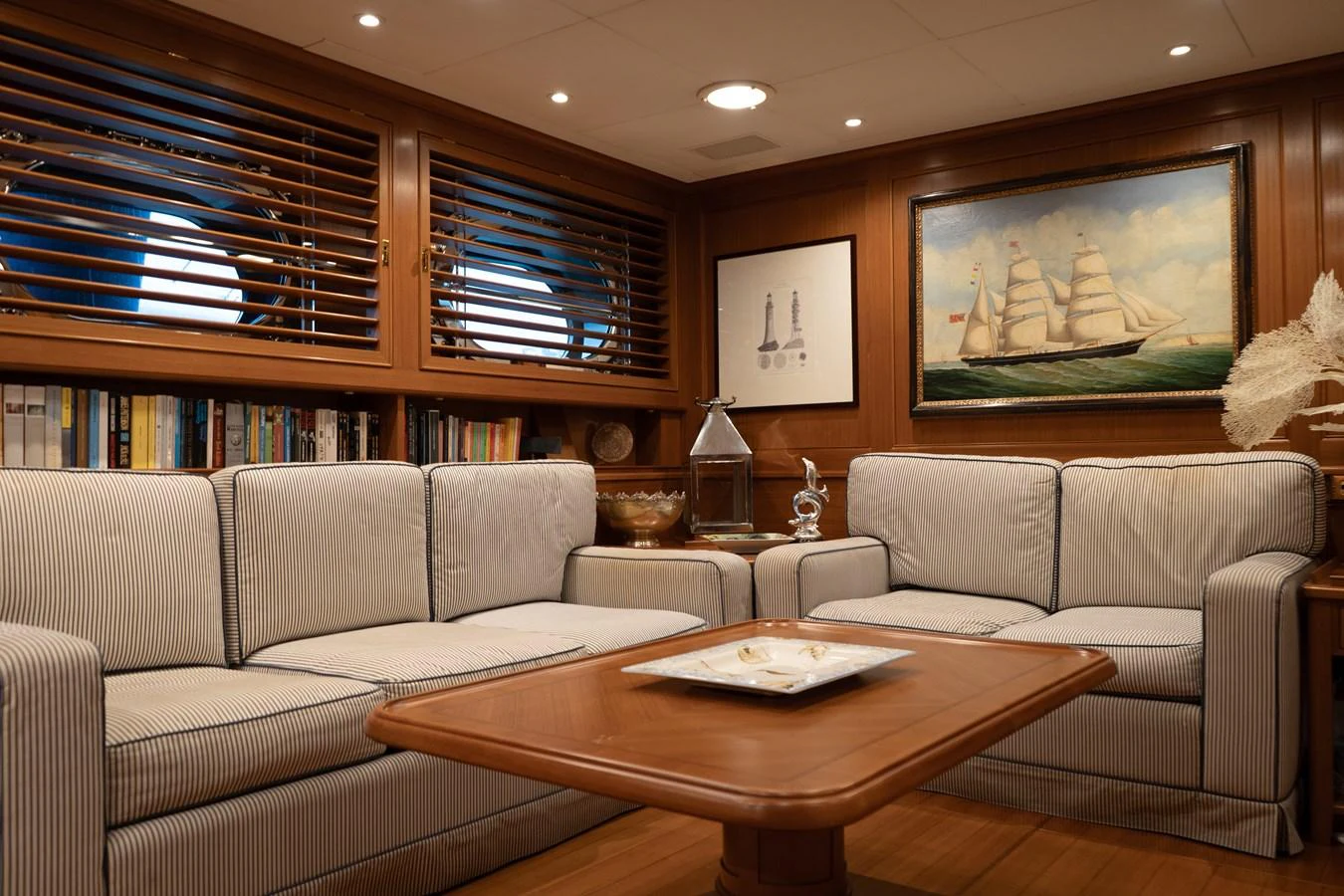 The salon features comfortable seating with a nautical theme and elegant wood finishes. aboard HERITAGE M Yacht for Sale