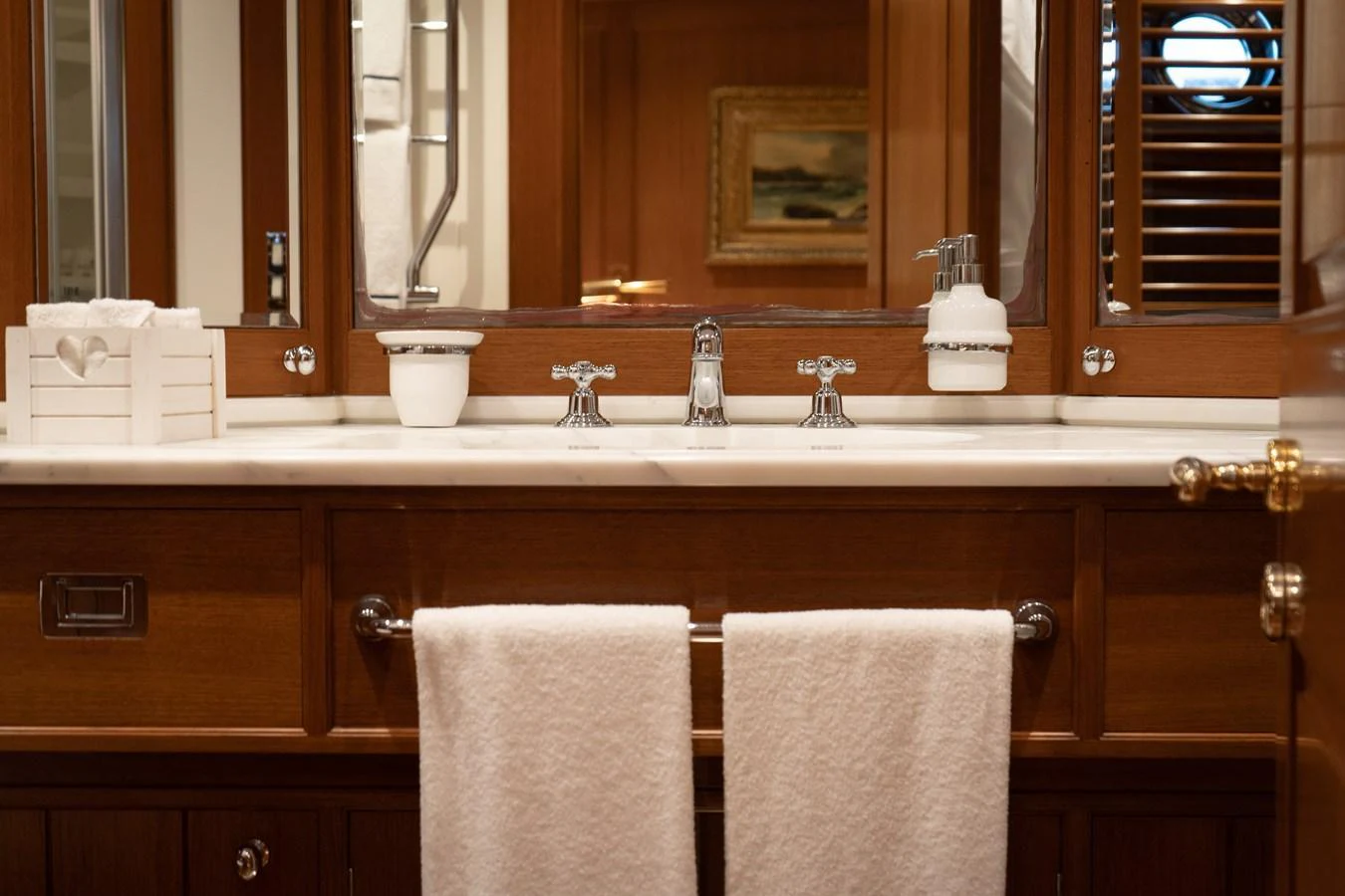 The yacht's bathroom features elegant wooden cabinetry and modern fixtures. aboard HERITAGE M Yacht for Sale