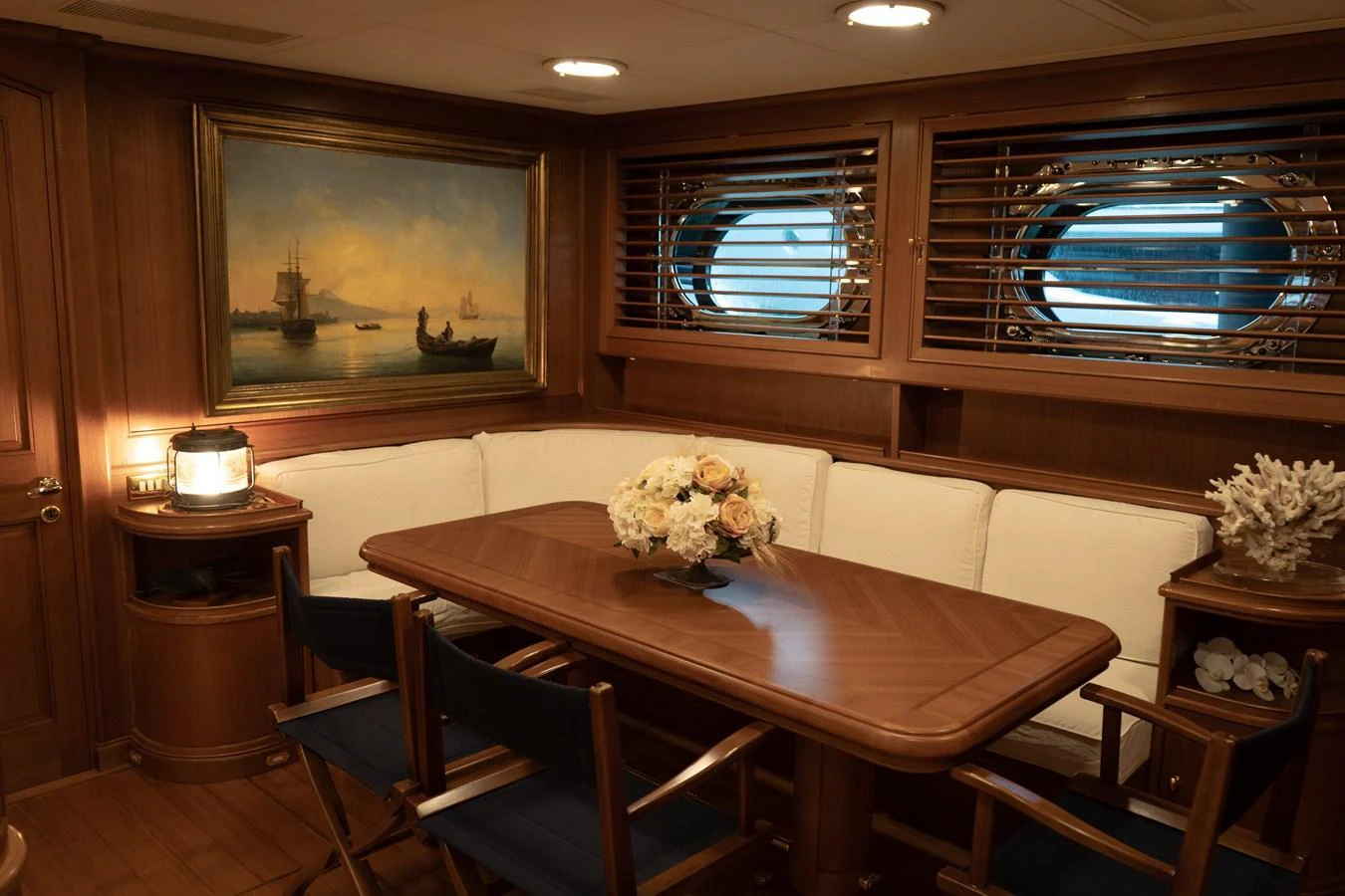 A cozy dining area with elegant wooden furnishings and nautical-themed decor. aboard HERITAGE M Yacht for Sale