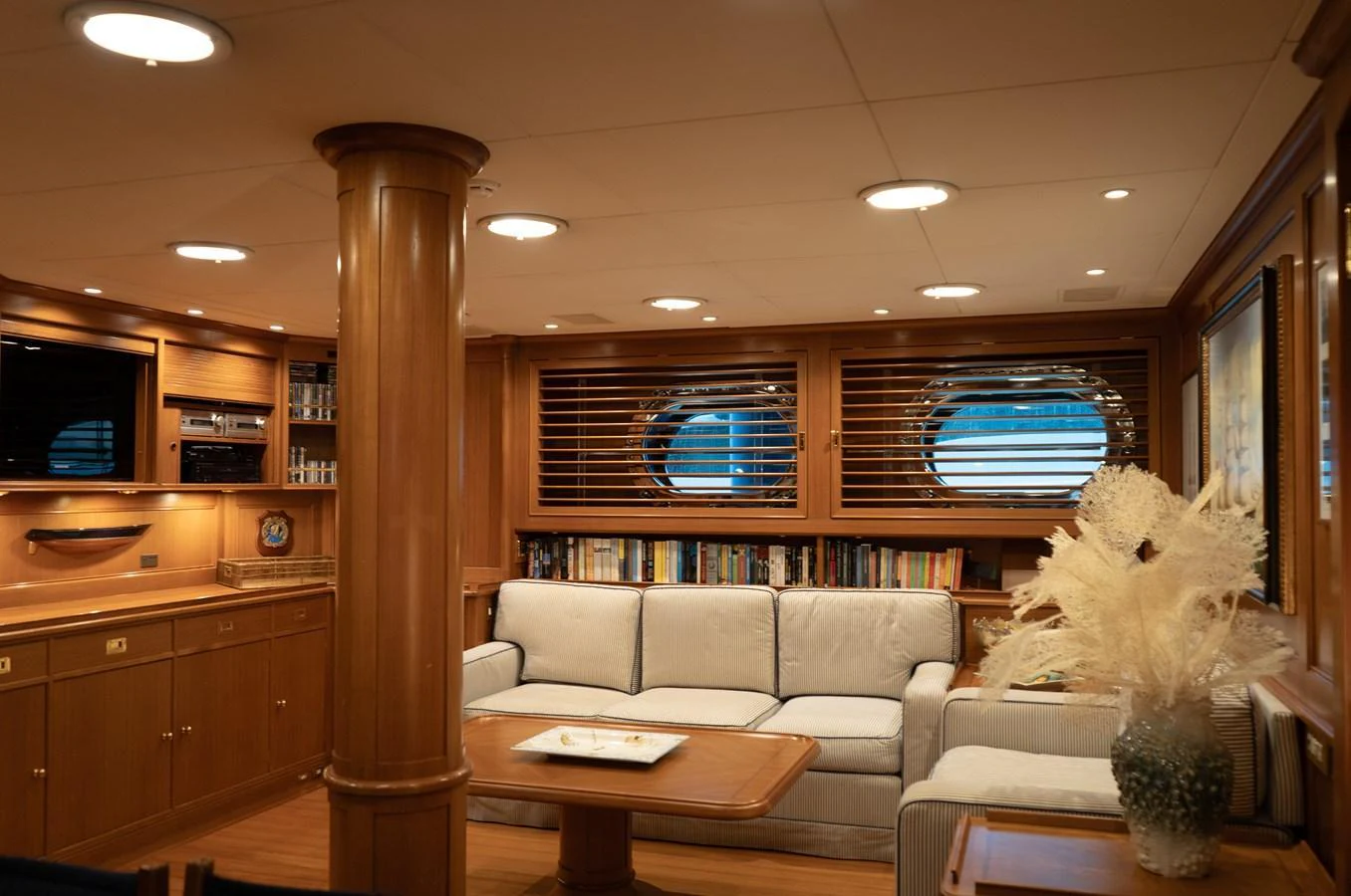 The yacht's salon features comfortable seating, warm wood finishes, and ample natural light through large windows. aboard HERITAGE M Yacht for Sale