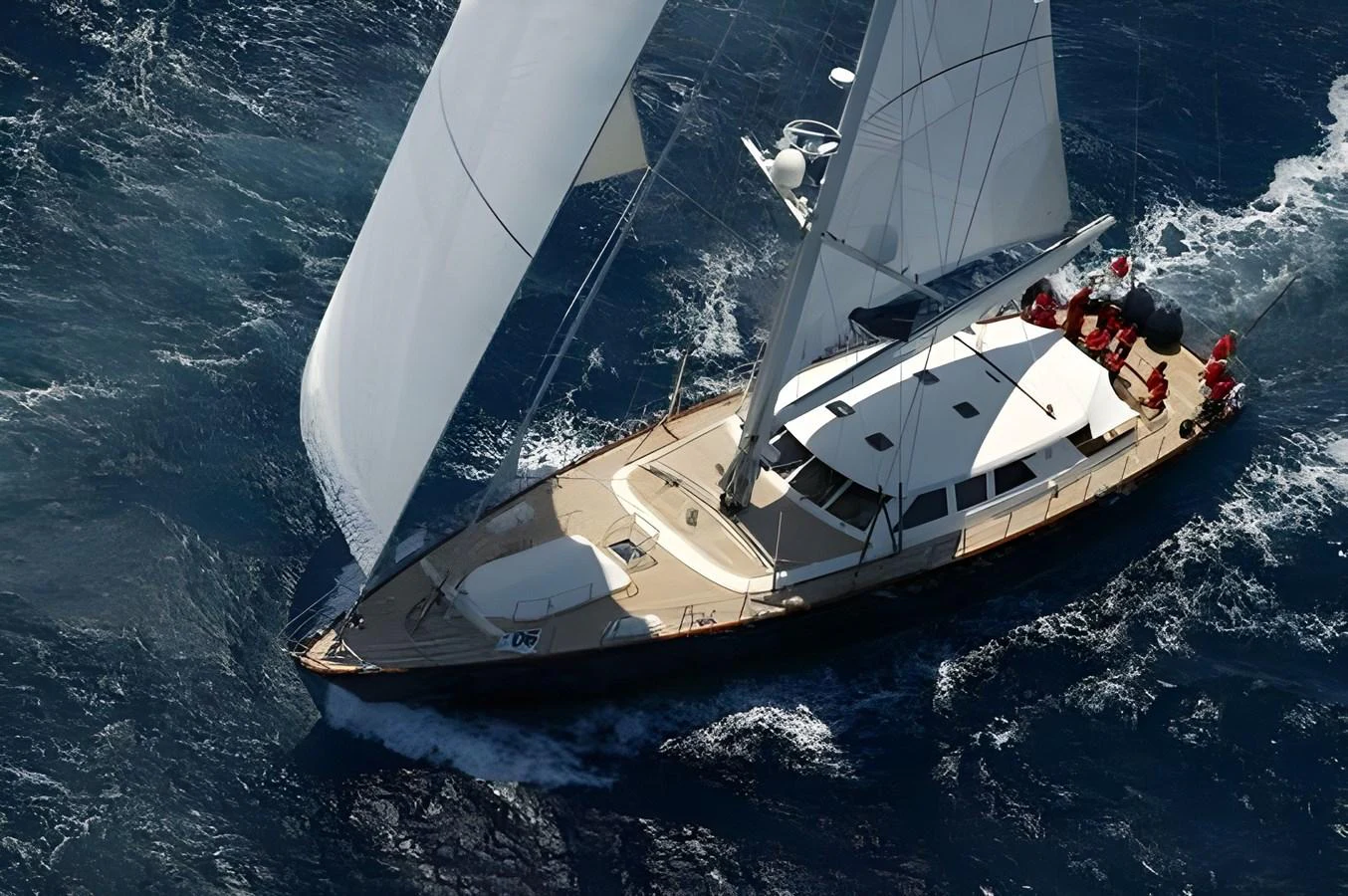 A sleek sailing yacht gracefully glides through the open sea with its sails fully extended. aboard HERITAGE M Yacht for Sale
