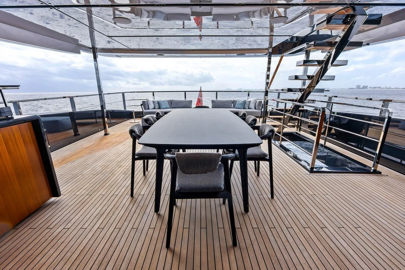 The aft deck features a stylish dining area with a sleek table and comfortable chairs, perfect for alfresco dining with a view of the sea. aboard EURO Yacht for Sale