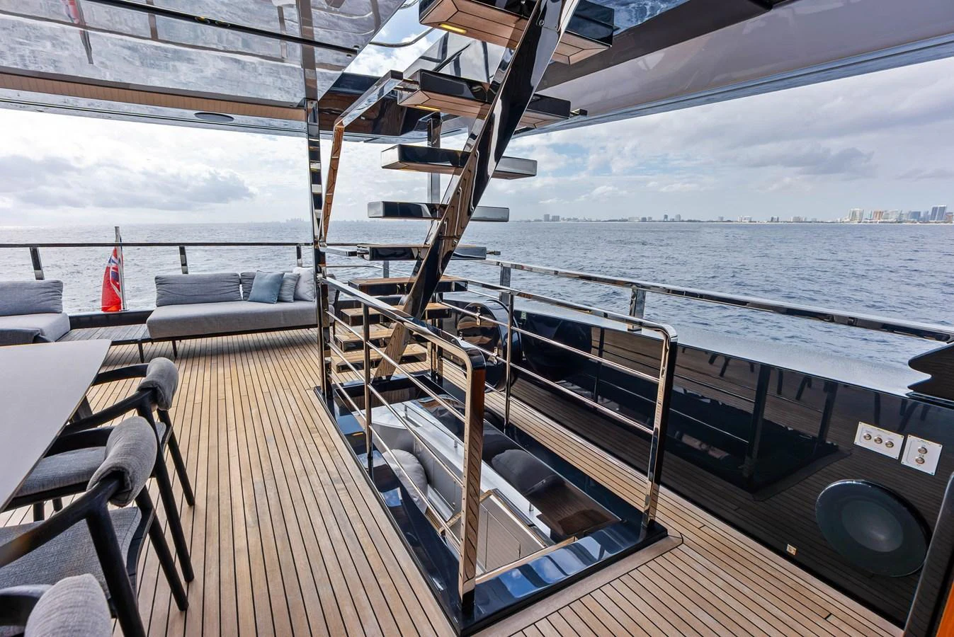 The aft deck features a sleek staircase and comfortable seating with a stunning ocean view. aboard EURO Yacht for Sale