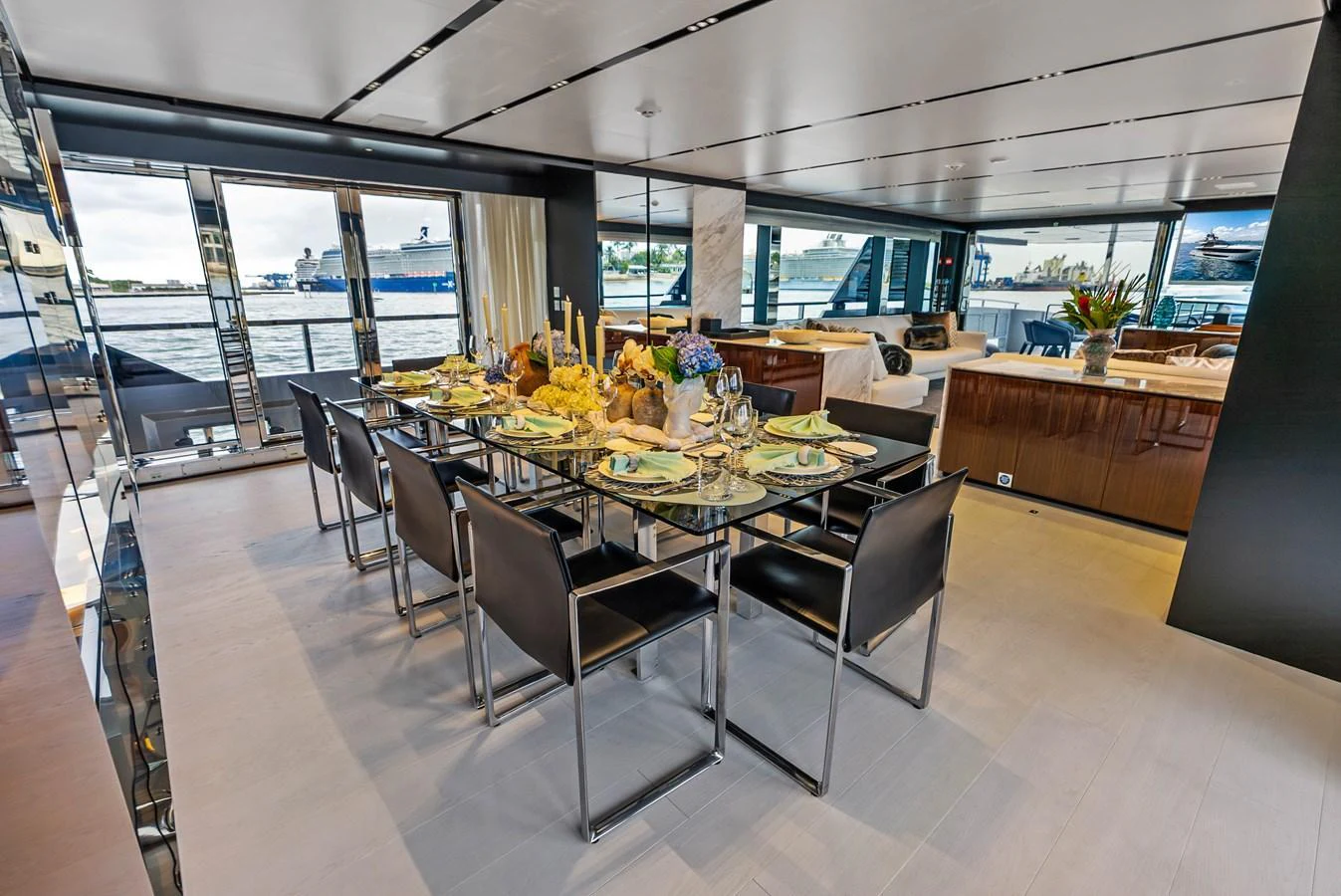 The yacht's dining area features a modern glass table set for an elegant meal, with panoramic views through large windows. aboard EURO Yacht for Sale
