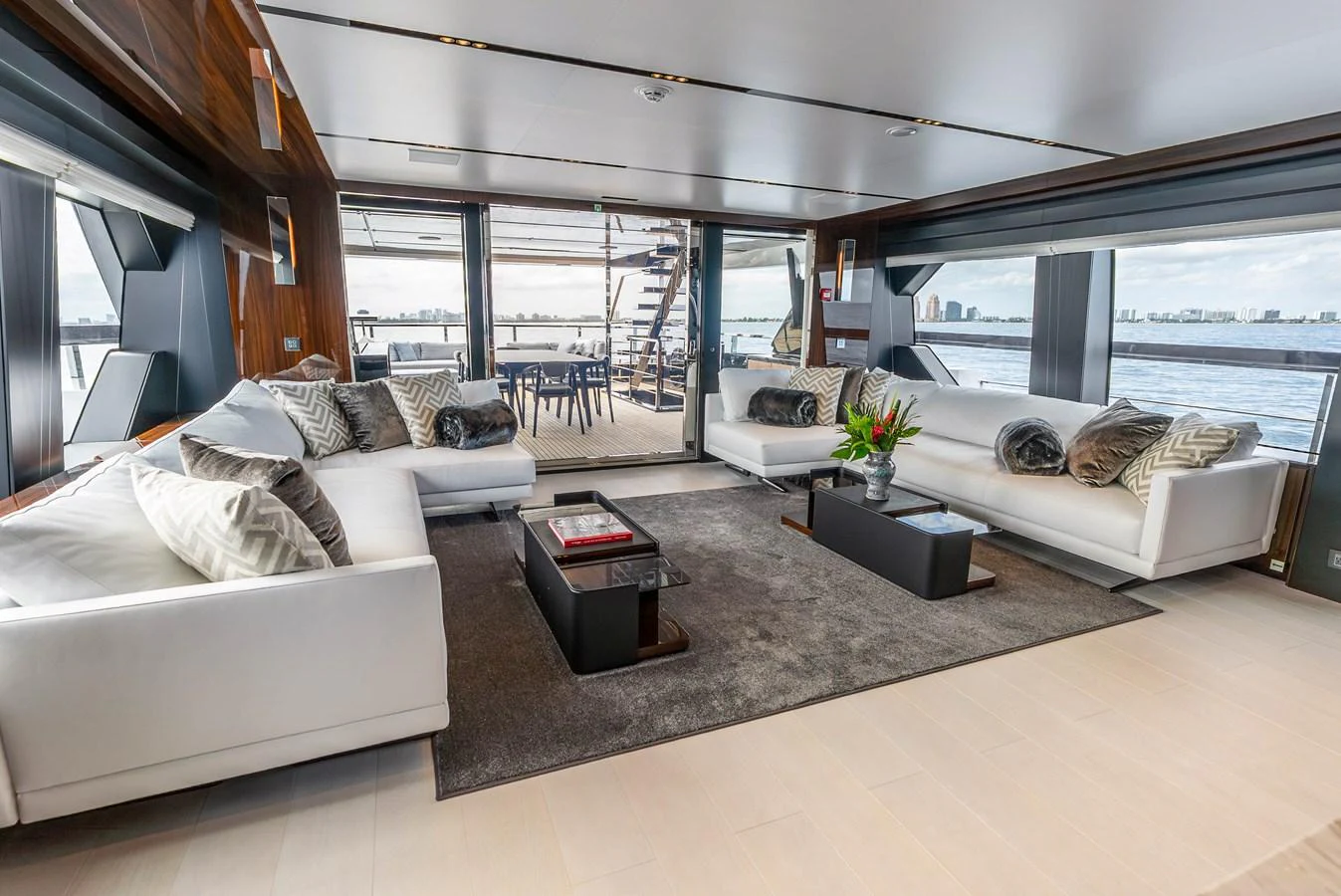 The salon features plush white seating, modern decor, and expansive windows offering stunning views. aboard EURO Yacht for Sale