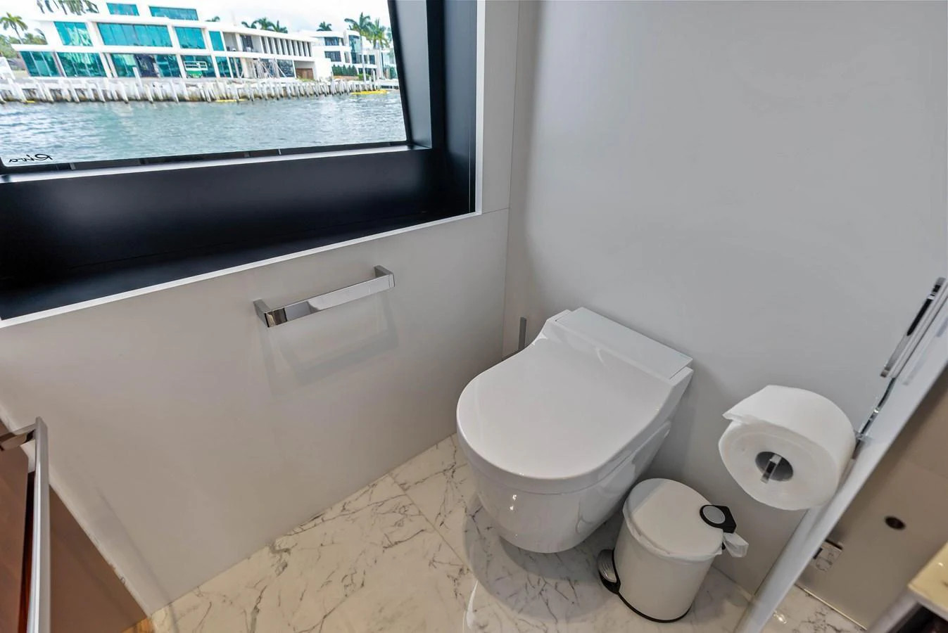 The yacht's head features a modern toilet with a view of the water through a window. aboard EURO Yacht for Sale