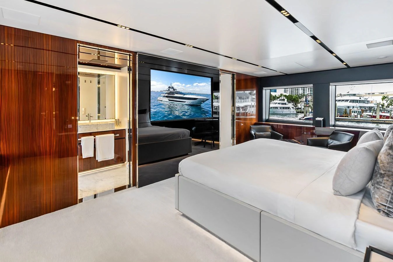 The master stateroom features a luxurious bed, elegant wood paneling, and large windows offering stunning views. aboard EURO Yacht for Sale