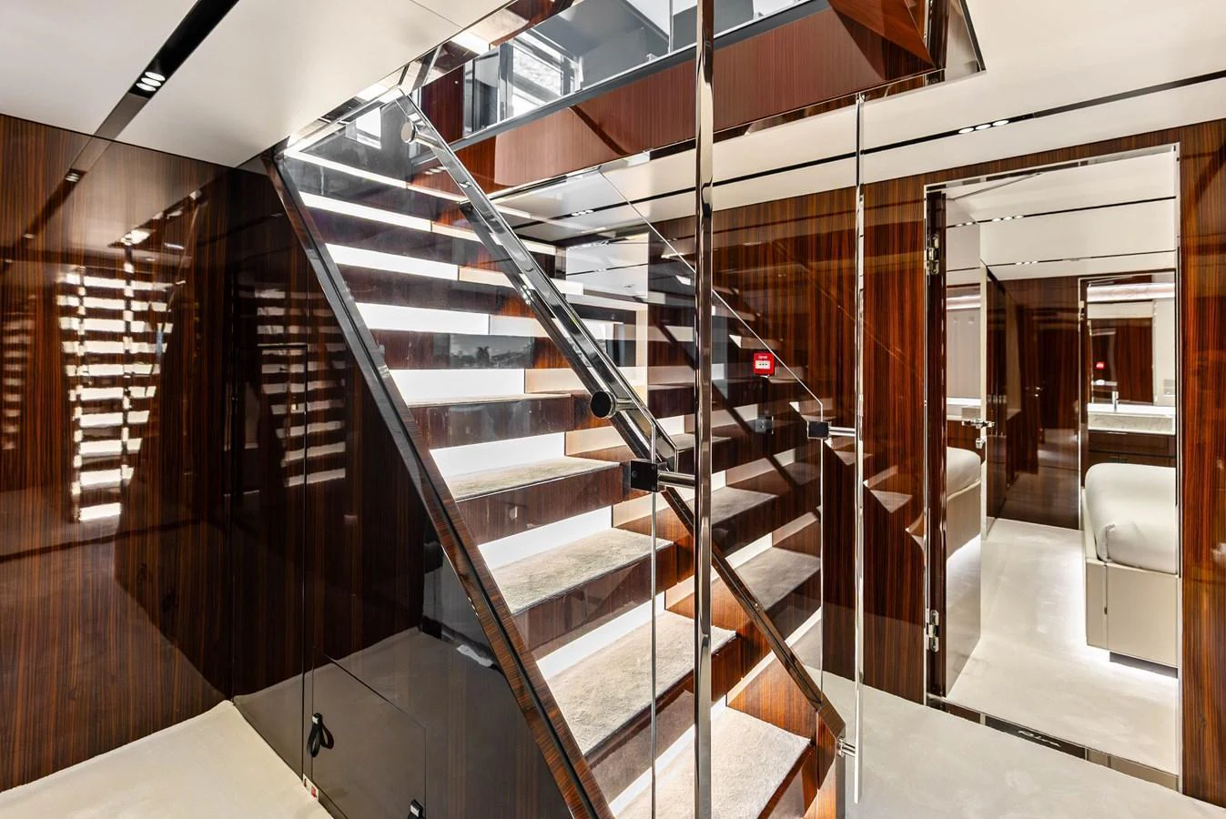 The yacht's interior features a sleek, modern staircase with polished wood and glass accents. aboard EURO Yacht for Sale