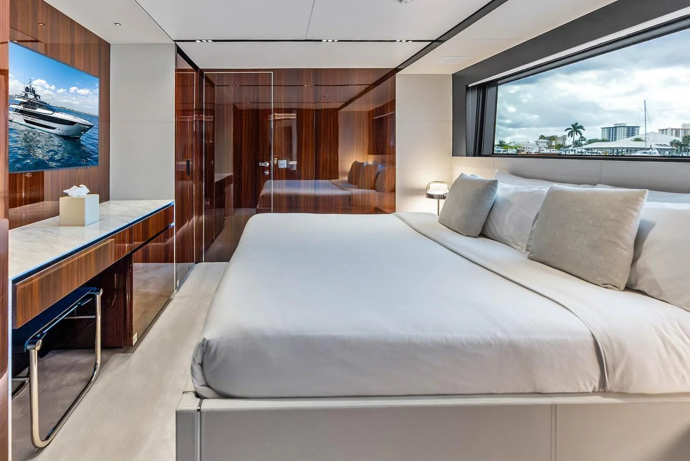 The stateroom features a luxurious bed with a scenic view through the large window. aboard EURO Yacht for Sale