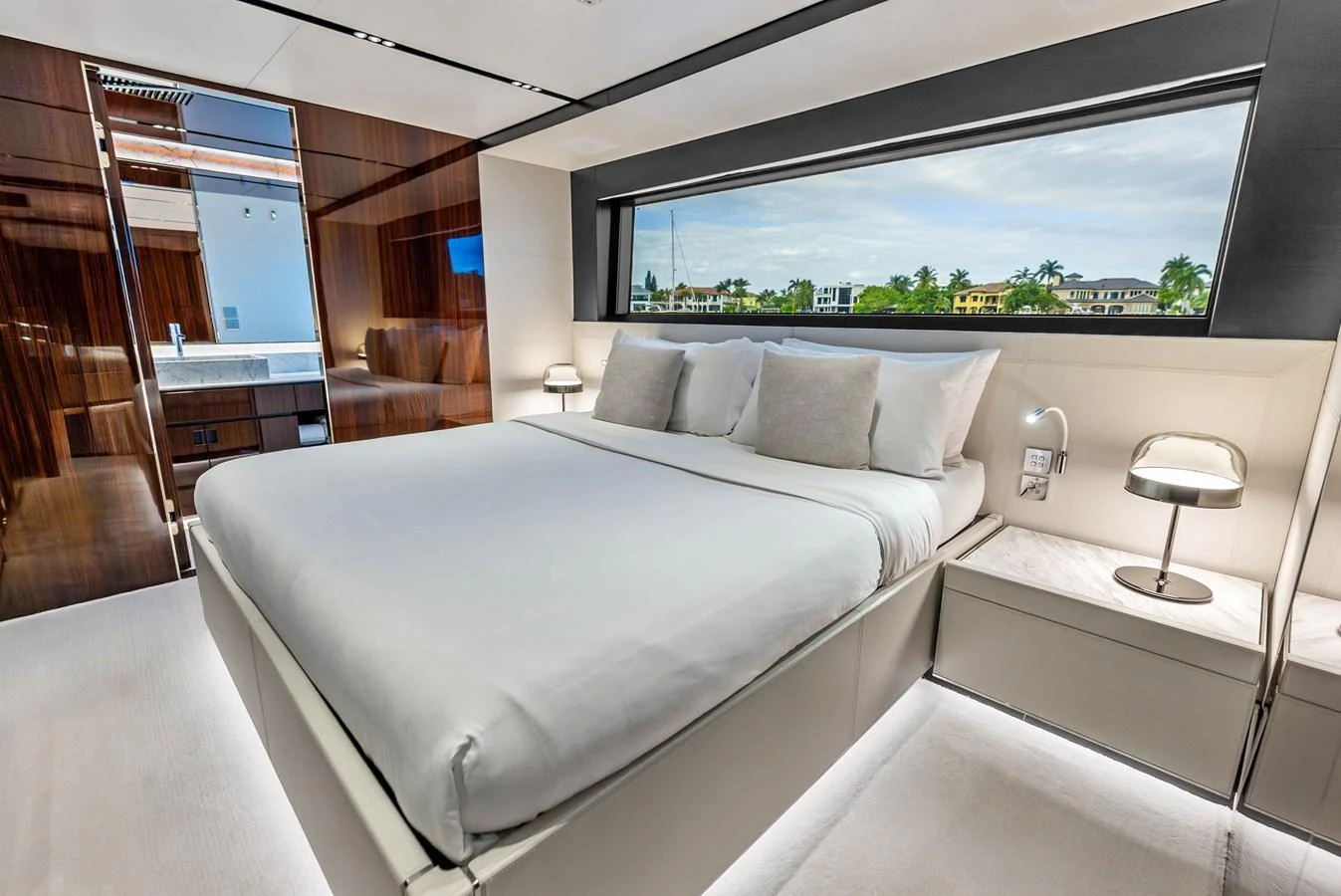 The stateroom features a luxurious bed with a large window offering scenic views. aboard EURO Yacht for Sale