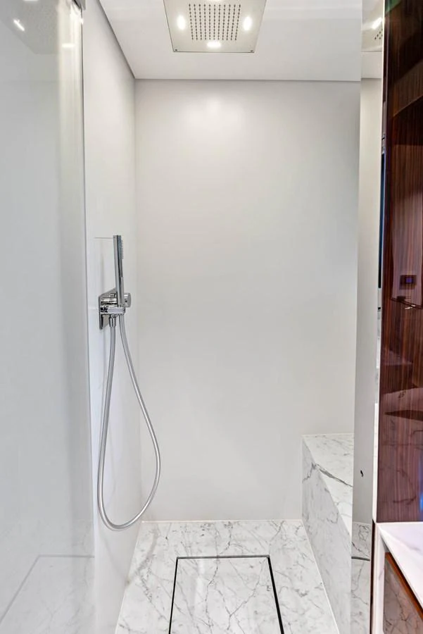 The yacht's bathroom features a sleek, modern shower with marble flooring and minimalist fixtures. aboard EURO Yacht for Sale