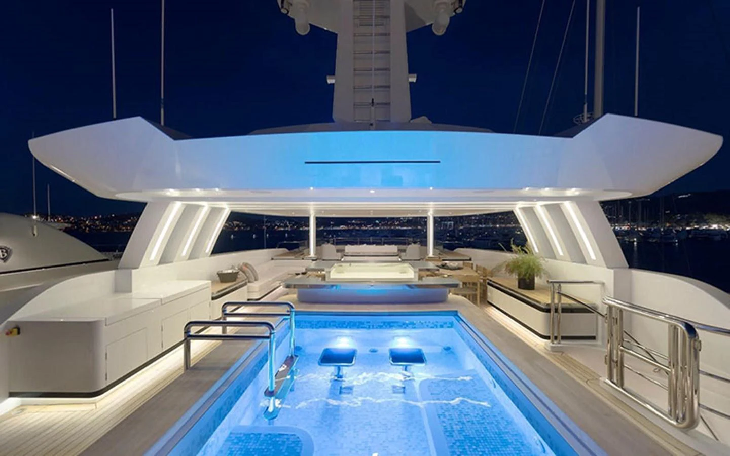 The sundeck features a luxurious pool area illuminated beautifully at night. aboard CMB  108 Yacht for Sale