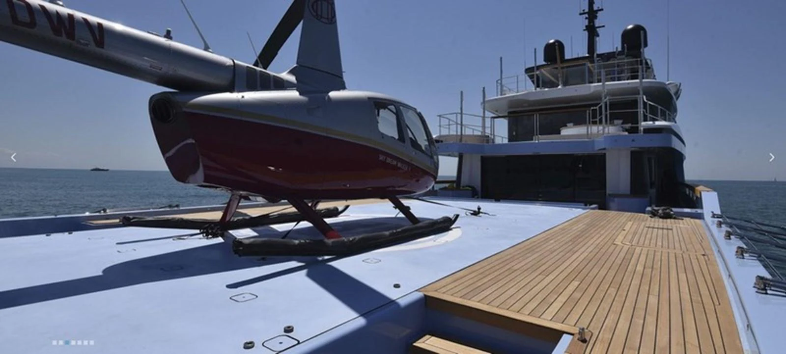 The yacht features a spacious helipad with a helicopter on deck, showcasing its luxury and convenience. aboard OCEAN DREAMWALKER III Yacht for Sale