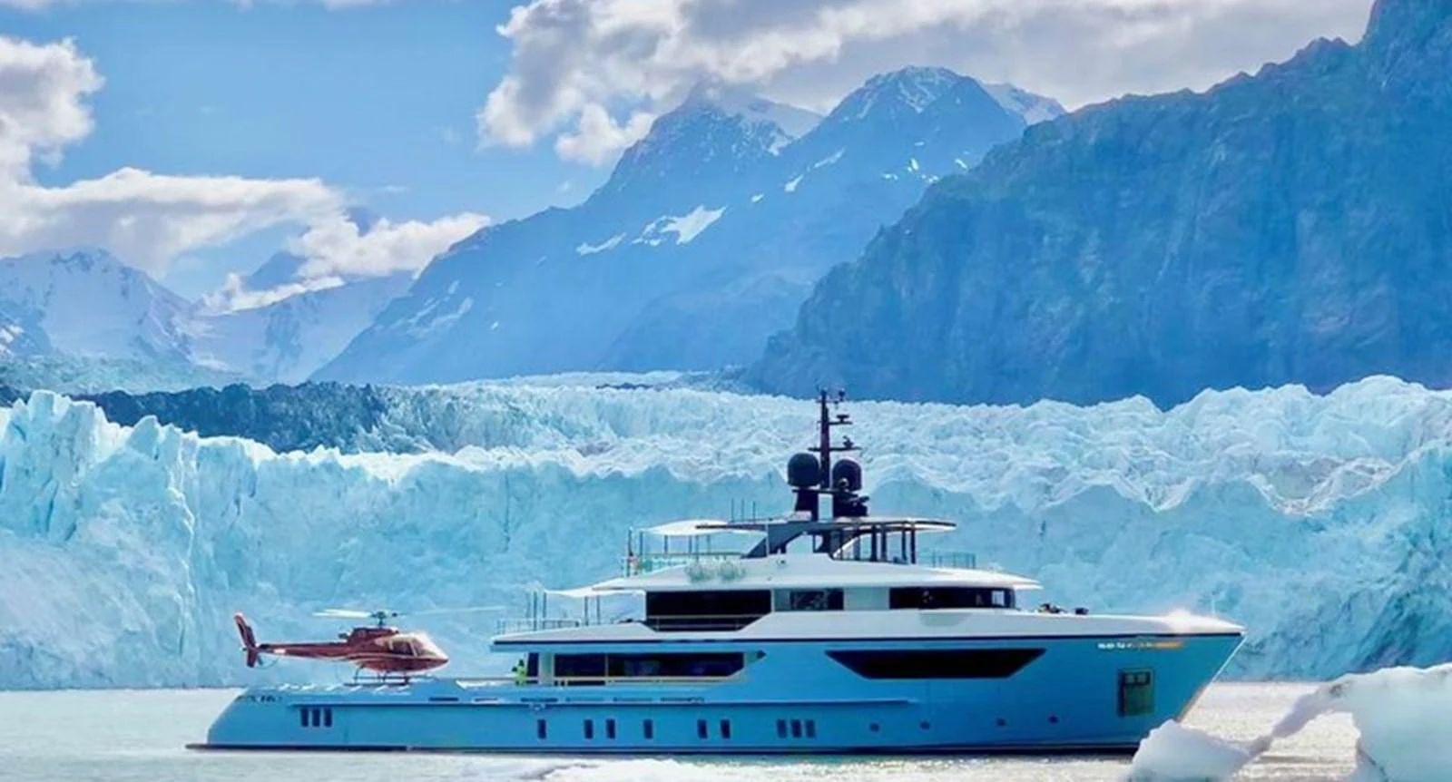 A luxurious yacht cruises through icy waters with a stunning mountainous backdrop. aboard OCEAN DREAMWALKER III Yacht for Sale