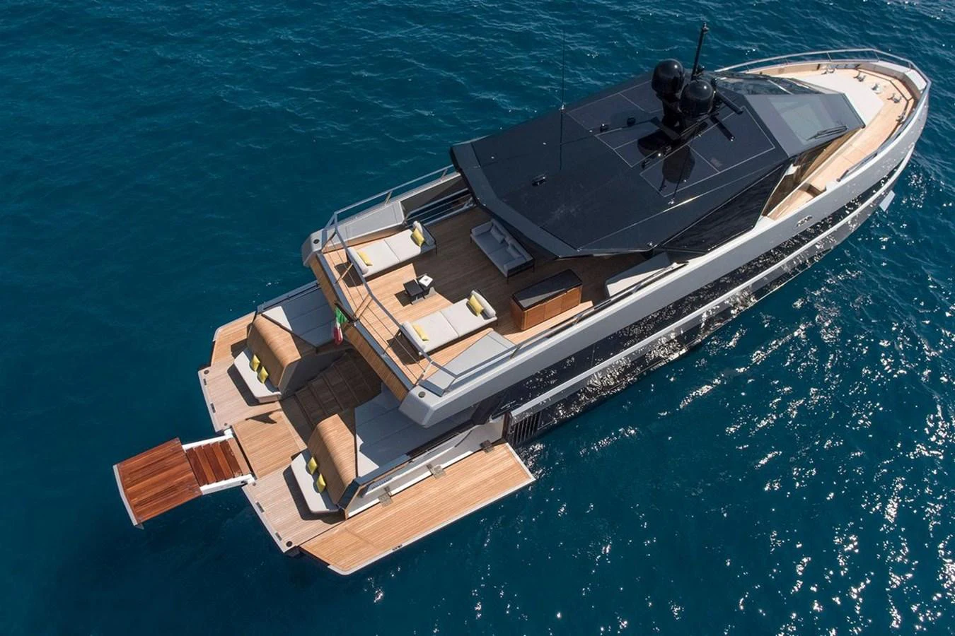 A sleek yacht with a spacious aft deck cruising on clear blue waters. aboard CARAT Yacht for Sale