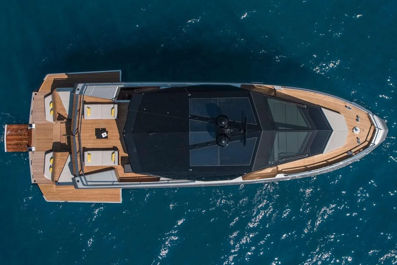 A sleek and modern yacht is seen from an aerial view, showcasing its spacious deck and elegant design. aboard CARAT Yacht for Sale