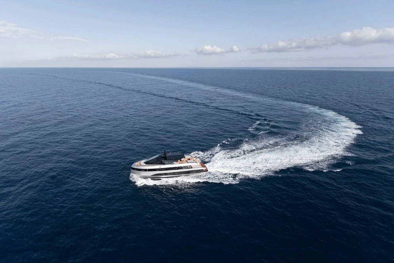 A sleek yacht glides gracefully across the open sea, leaving a trail of white wake behind. aboard CARAT Yacht for Sale
