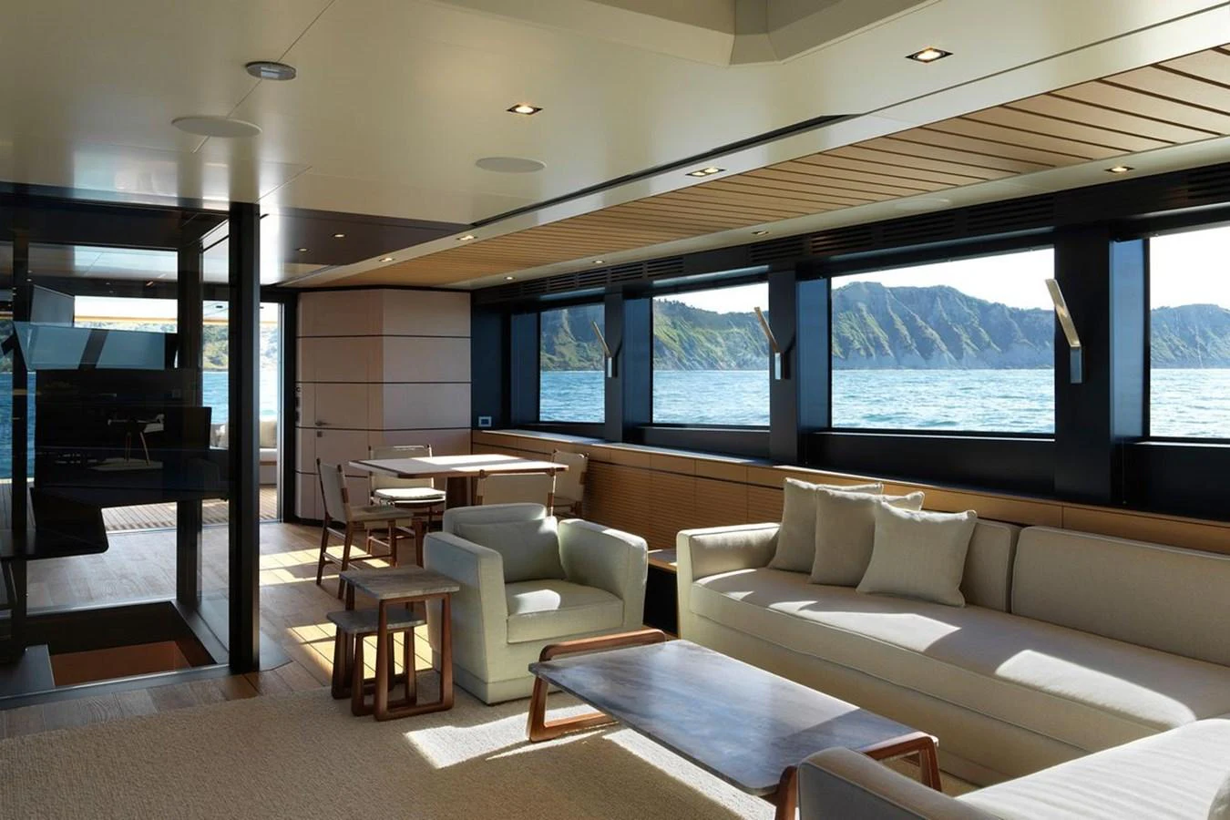 The yacht's salon features elegant seating with panoramic windows offering stunning ocean views. aboard CARAT Yacht for Sale