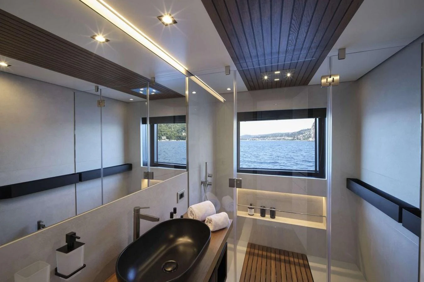 The yacht's bathroom features a sleek design with a large window offering a stunning view of the water. aboard CARAT Yacht for Sale