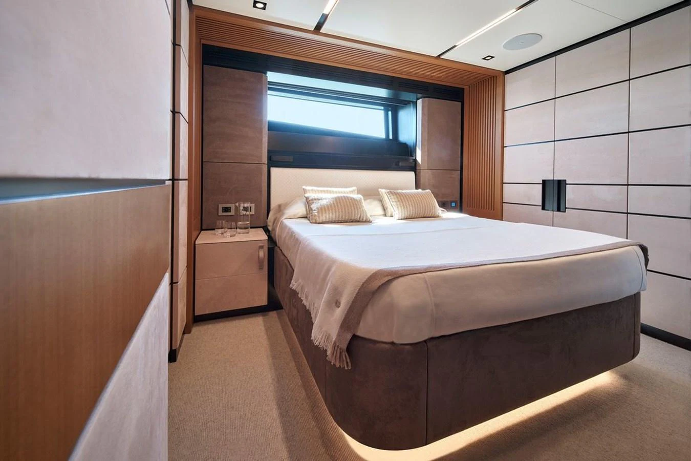 The stateroom features a modern design with a comfortable bed and elegant lighting. aboard CARAT Yacht for Sale