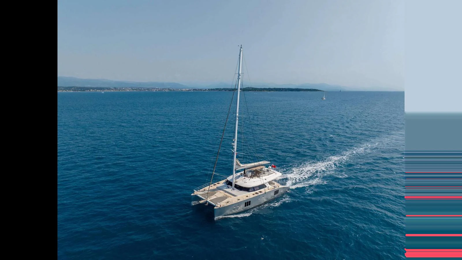 A sleek catamaran sailing smoothly on a calm sea under a clear sky. aboard SEAZEN II Yacht for Sale