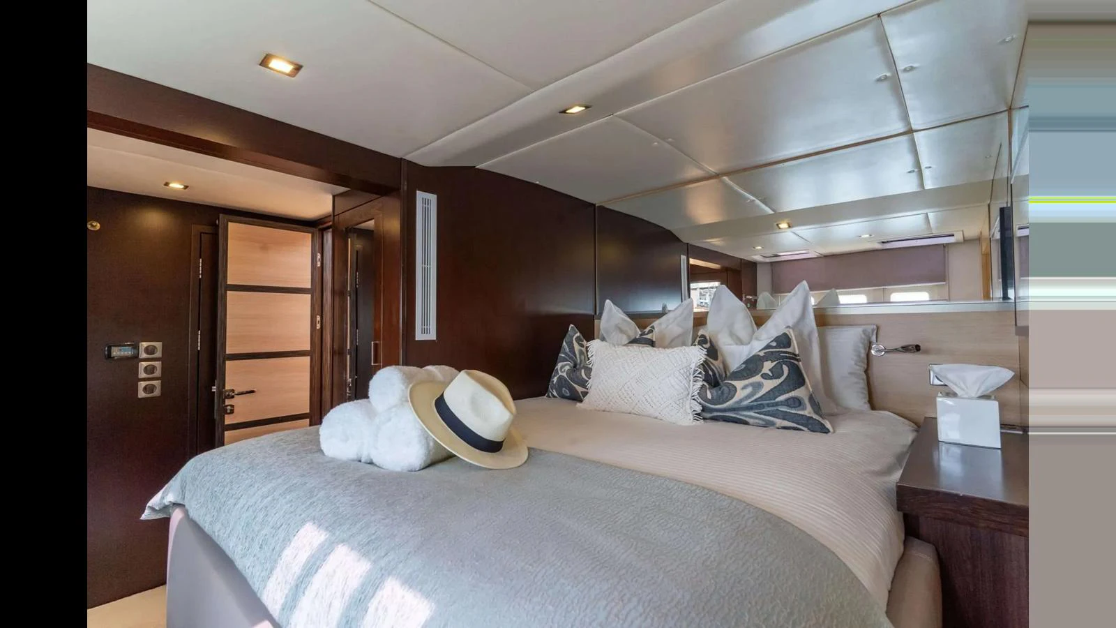 The master stateroom features a luxurious bed adorned with plush pillows and a stylish hat, creating a serene and inviting atmosphere. aboard SEAZEN II Yacht for Sale