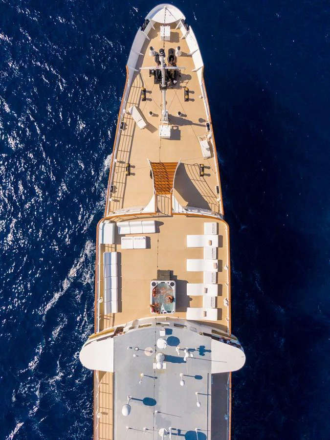 An aerial view of the yacht showcases its expansive deck and luxurious amenities against the deep blue sea. aboard HARMONY II Yacht for Sale
