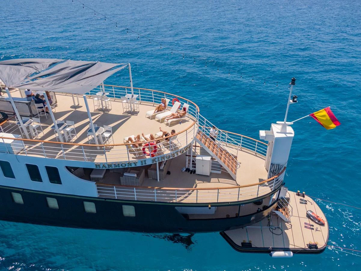 The yacht's aft deck offers a spacious lounging area with sunbeds and a shaded dining space, perfect for relaxation and entertainment on the water. aboard HARMONY II Yacht for Sale