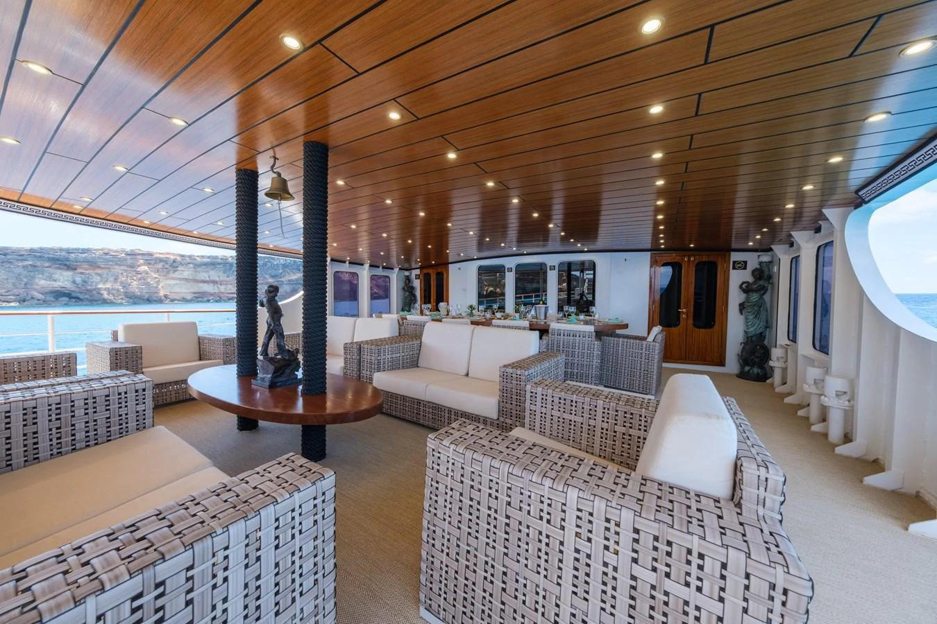 The aft deck features a spacious seating area with elegant wicker furniture and a wooden ceiling, perfect for relaxation and socializing. aboard HARMONY II Yacht for Sale