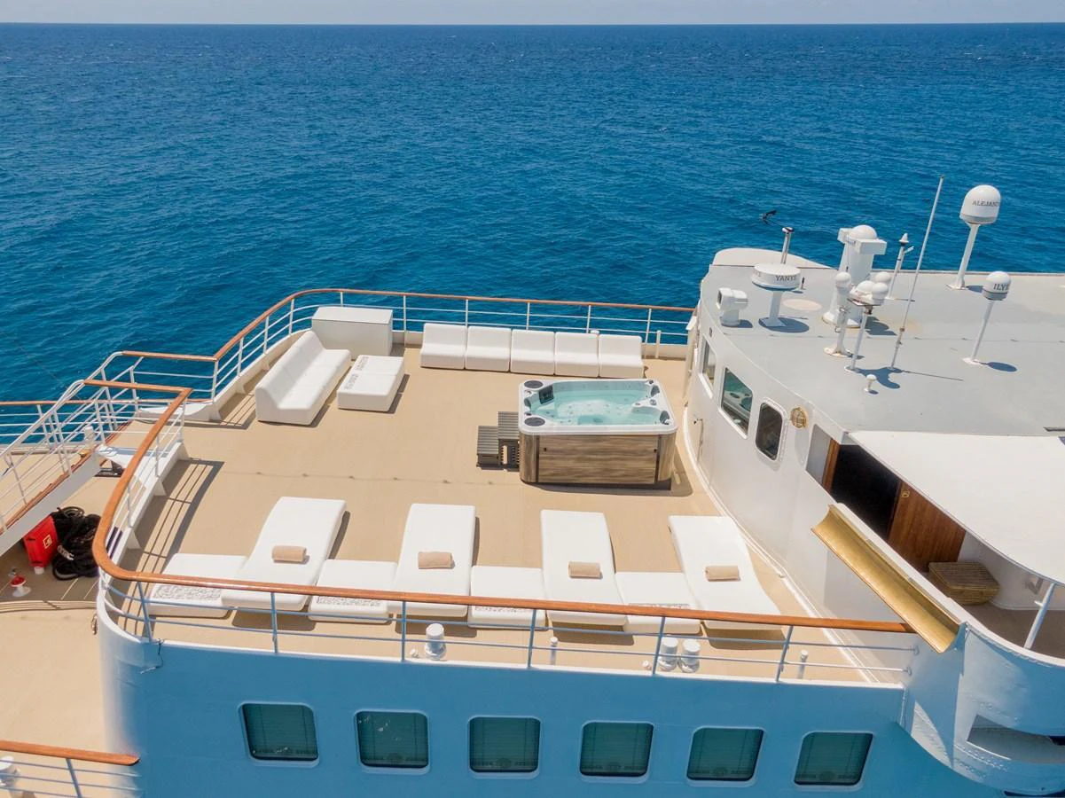 The yacht's sundeck features a luxurious hot tub surrounded by ample sun loungers, perfect for relaxation. aboard HARMONY II Yacht for Sale