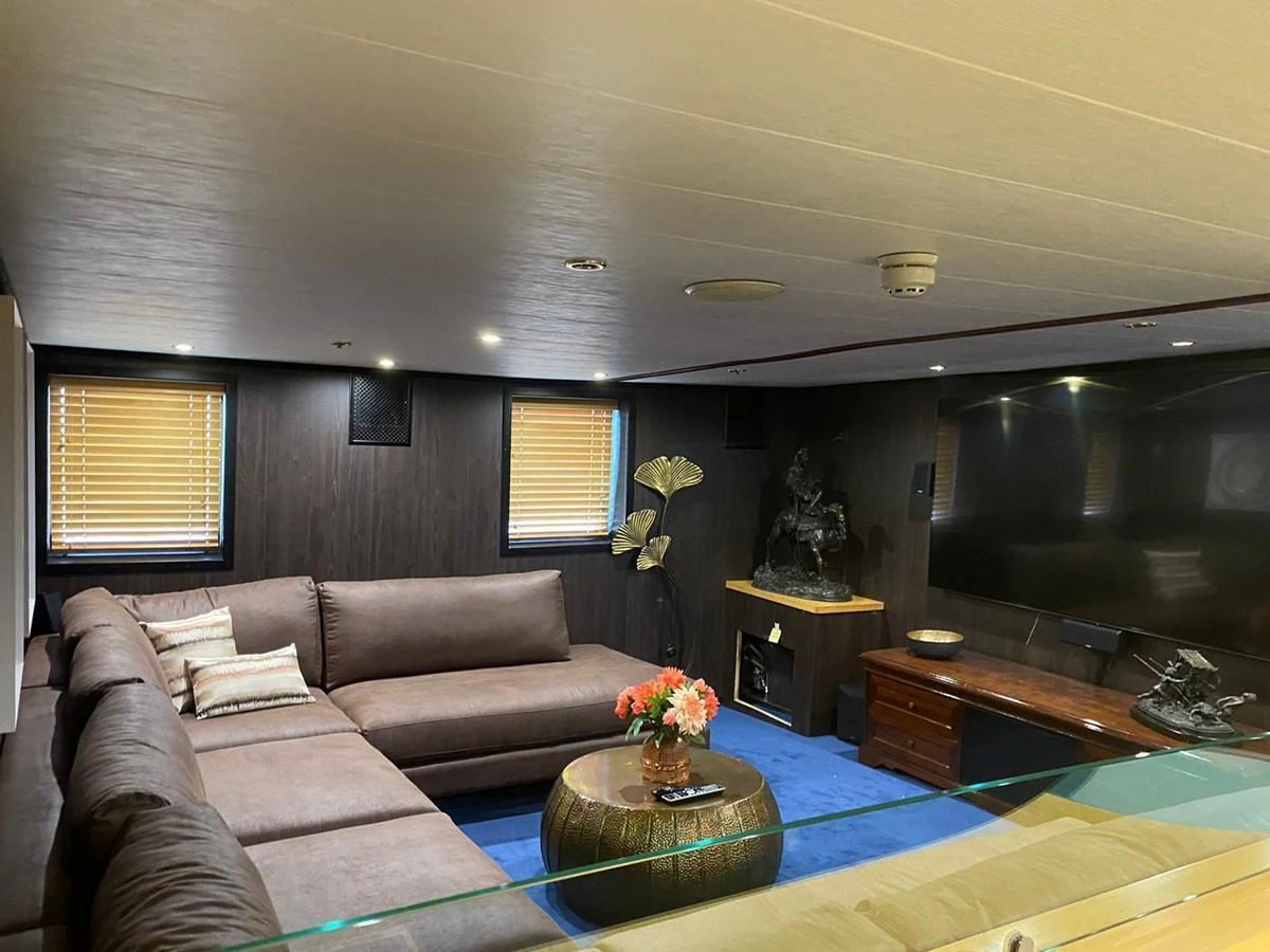 The salon features a spacious seating area with a large sectional sofa and entertainment setup. aboard HARMONY II Yacht for Sale