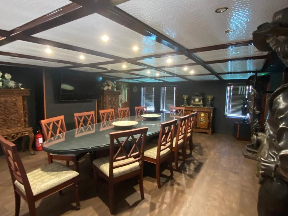 The yacht's dining area features an elegant table surrounded by wooden chairs, creating a sophisticated atmosphere for meals. aboard HARMONY II Yacht for Sale