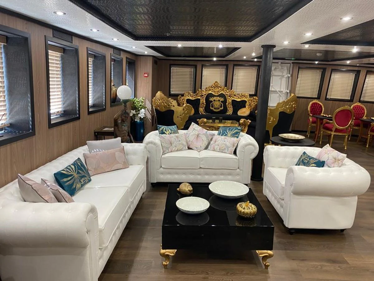 The salon features elegant white sofas, a black coffee table, and luxurious gold-accented decor. aboard HARMONY II Yacht for Sale