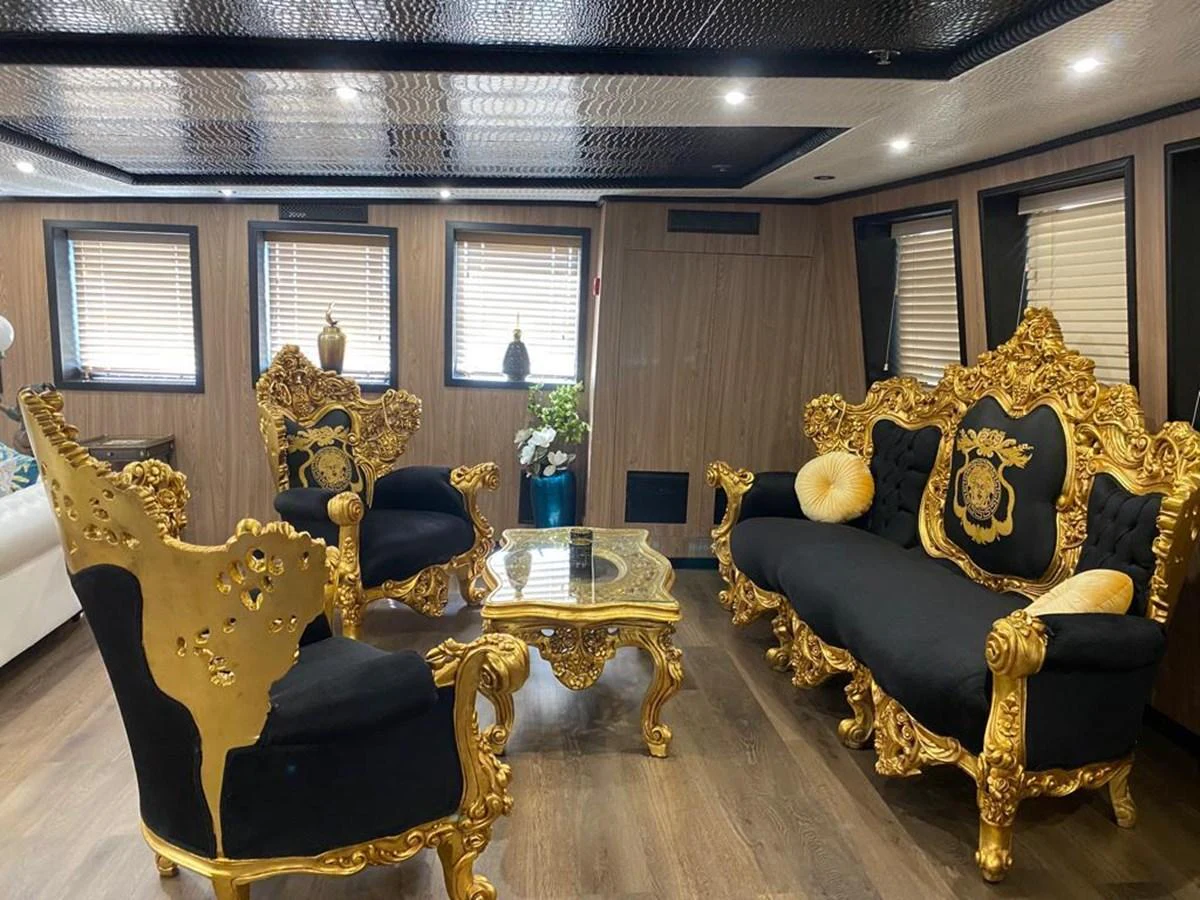 The salon features opulent gold and black furniture with intricate detailing, creating a luxurious and elegant atmosphere. aboard HARMONY II Yacht for Sale