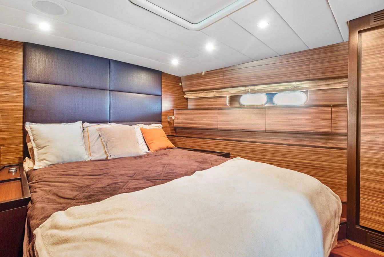 a bed with a wooden headboard aboard HAPPY ONE Yacht for Sale