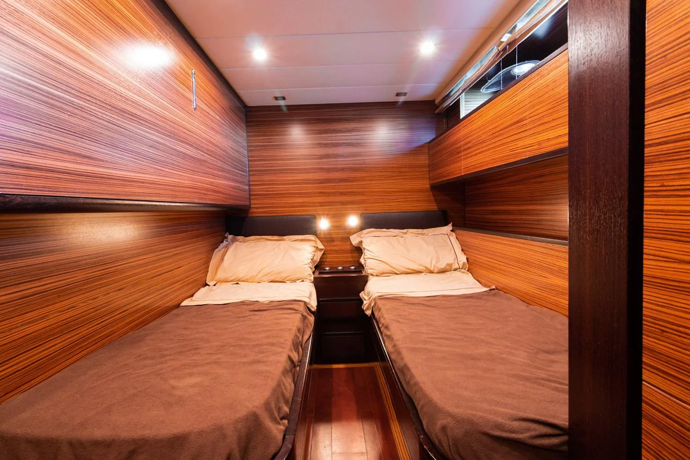 a room with wooden walls and wooden furniture aboard HAPPY ONE Yacht for Sale