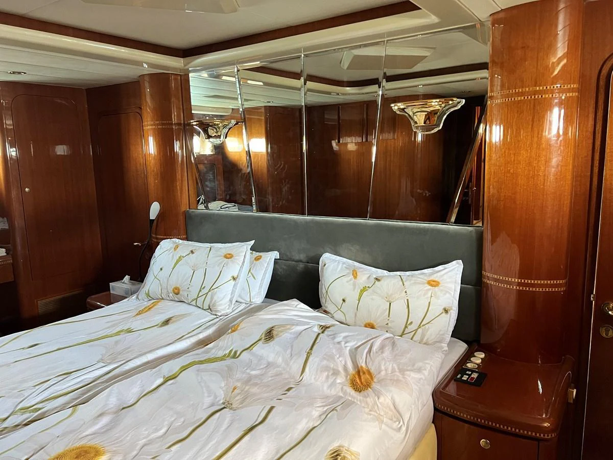 The master stateroom features a luxurious bed with elegant bedding and warm wood paneling. aboard HORIZON ELEGANCE 82 S Yacht for Sale