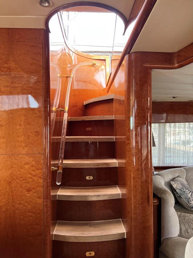 A beautifully crafted wooden staircase with elegant curves leads to the upper deck. aboard HORIZON ELEGANCE 82 S Yacht for Sale