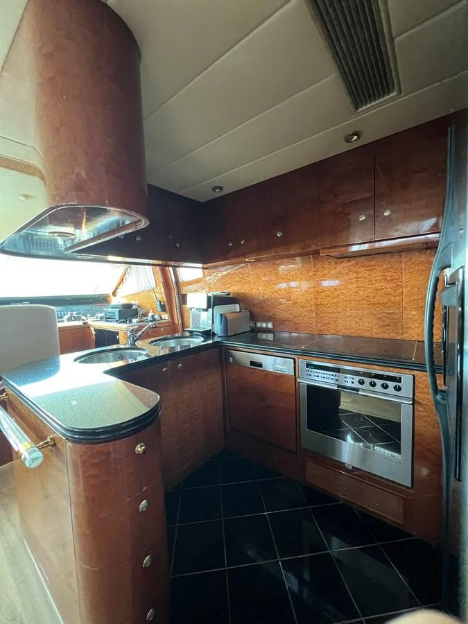 The yacht's galley features modern appliances and rich wood cabinetry, creating a warm and functional space. aboard HORIZON ELEGANCE 82 S Yacht for Sale