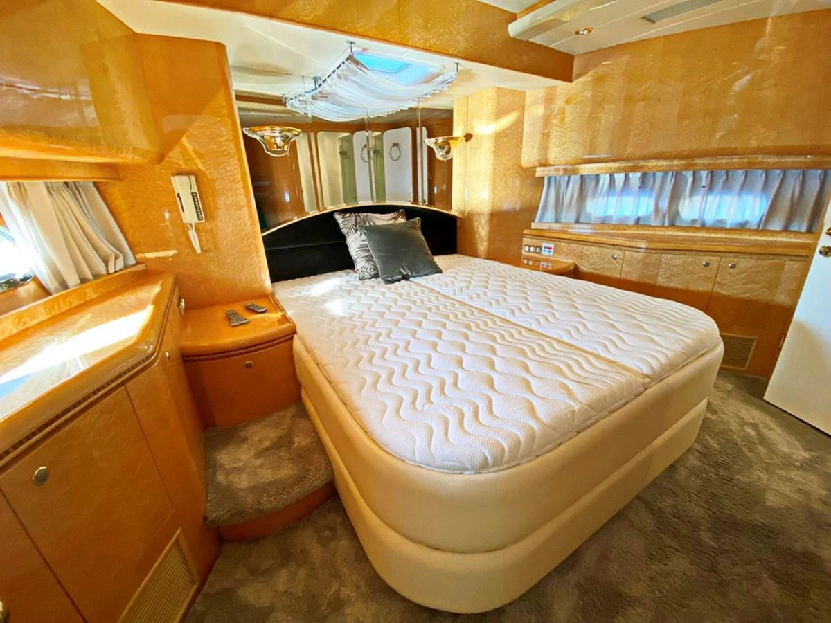 The stateroom features a plush bed with elegant wood finishes and ample natural light. aboard HORIZON ELEGANCE 82 S Yacht for Sale
